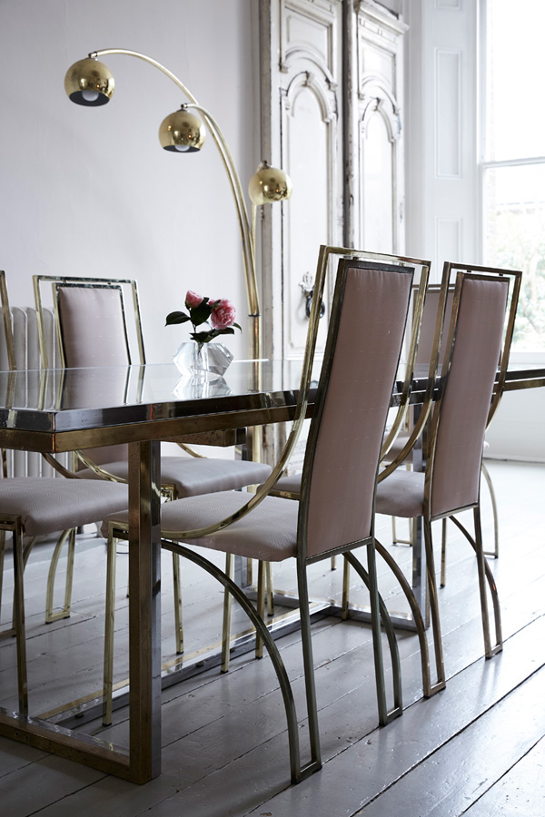 The dining space looks amazing with blush chairs and a modern gold and silver dining table