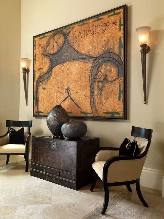 Warm colour palette and dark espresso furnishings and decor with 2 torch wall sconces flanking a large art work