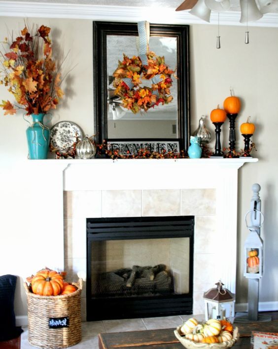 fall leaf wreath and bouquet in a vase, pumpkins on stands and a large framed mirror