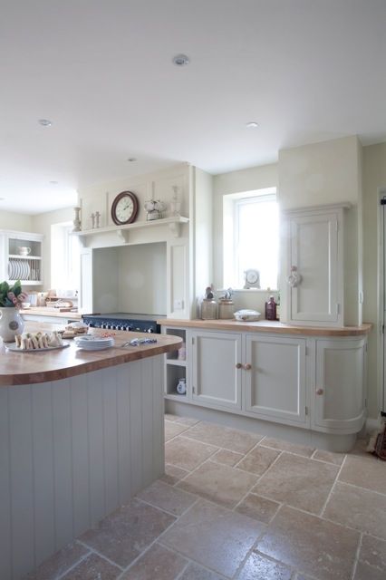 stone floors creates a modern feeling in this traditional kitchen