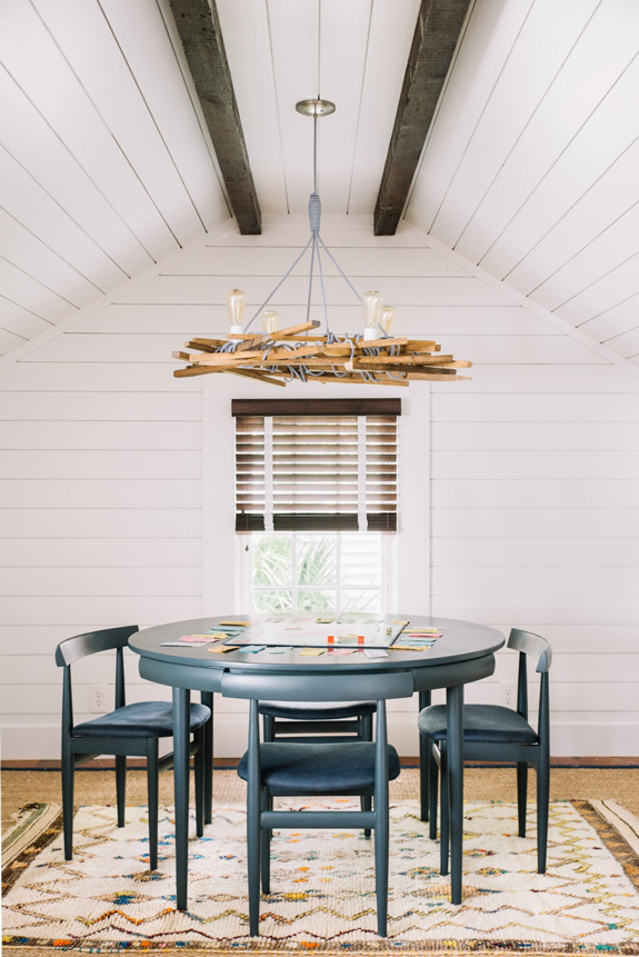 The dining zone is accentuated with a whimsy chandelier made of wood, rope and bulbs