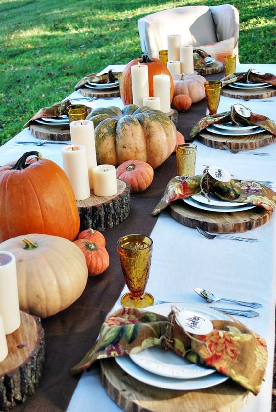 brown fabric table runner, natural pumpkins, candles on wood slices