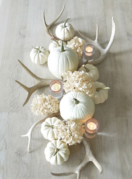 all-white fall table centerpiece with pumpkins, antlers and flowers