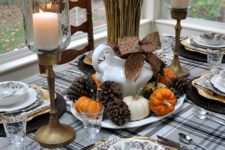 11 pinecones, tiny pumpkins and wheat for a centerpiece, black woven chargers and a plaid tablecloth and antique candle holders