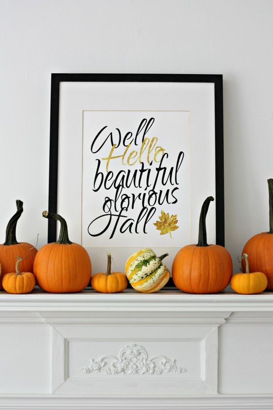 simple modern mantel with pumpkins and a framed artwork