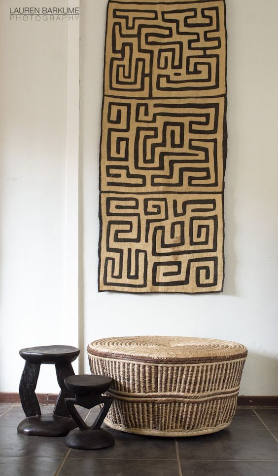 A woven table and wooden stools amde by African artisans and the Kuba cloth