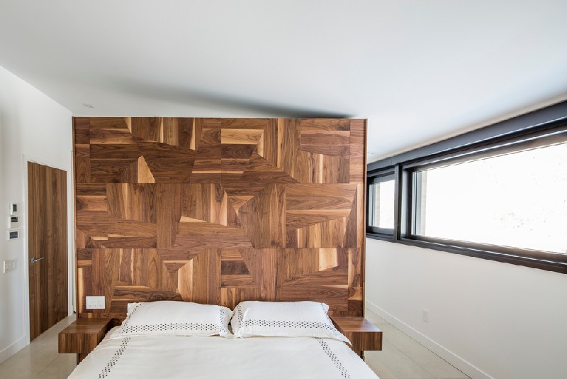 The bedroom can also boast of a statement wall but this one is made of geometrically clad wood
