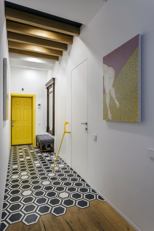 The hallway is bold and colorful, with creative geo tiles and the owner's art piece