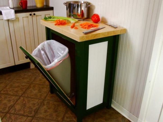 A kitchen trash can cabinet with a tilt open door