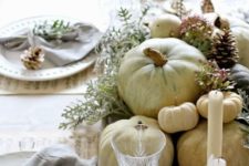 13 white pumpkins in a wooden tray, grey napkins and pinecones