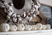 14 pumpkins with letters and a cotton wreath