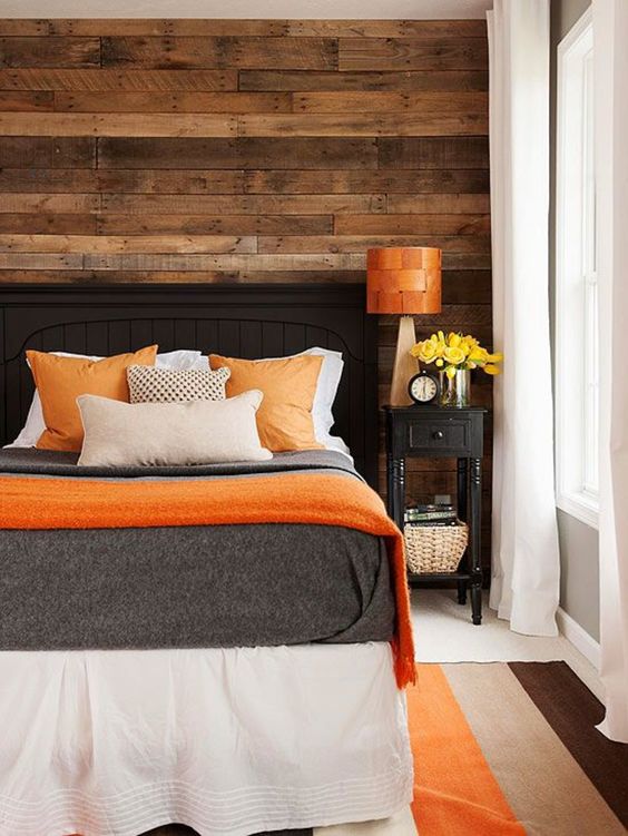 warm wood and orange accents make this bedroom inviting and positive