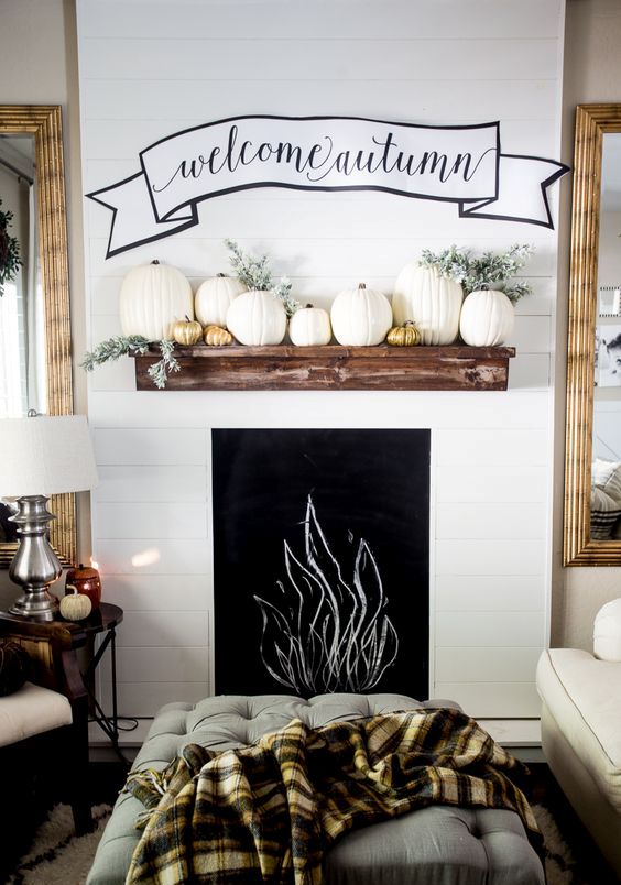 faux mantel with pumpkins and a fabric wall decoration
