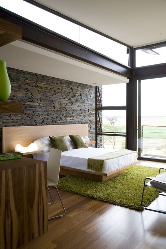 ultra-modern bedroom with a stone wall that gives texture to the room
