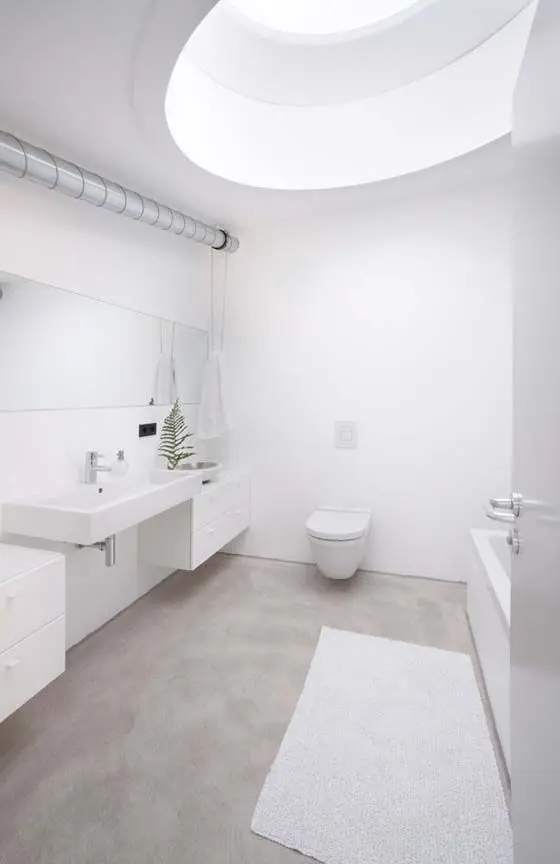 Natural concrete floor for a clean all white bathroom