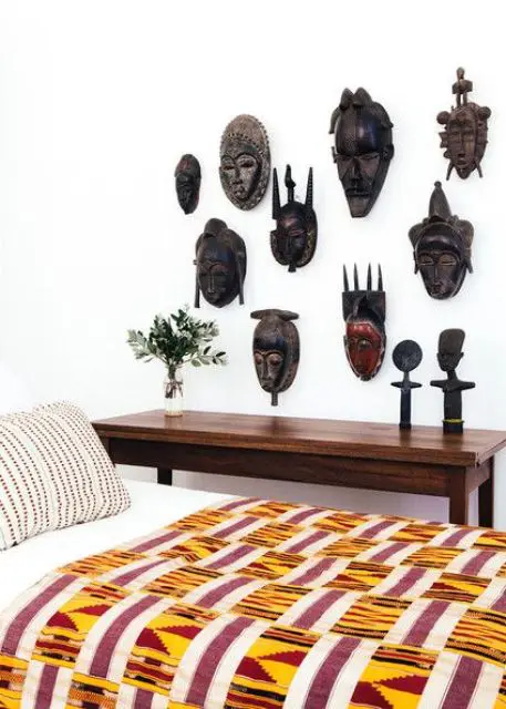 20 A collection of African carved masks on a bedroom wall for a statement