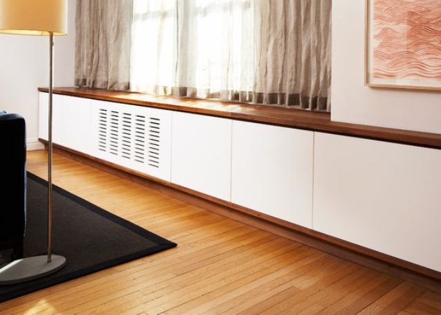white and natural wood radiator cover attached to the window sill