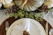 21 fall pumpkins, pinecones and greenery centerpiece, a woven charger and a pinecone napkin ring