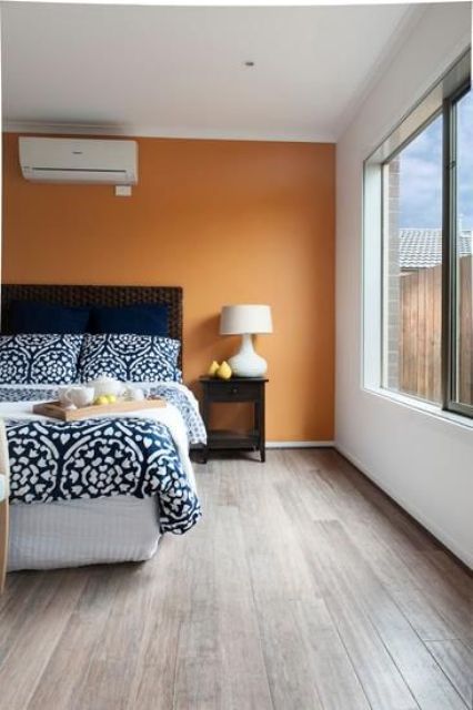 light brown flooring soothes the orange accent wall