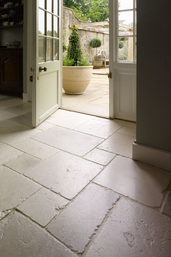 beautifully aged limestone floors in the entryway and outdoors to connect spaces