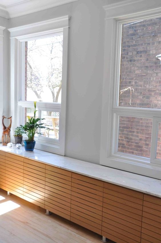 wooden radiator cover that serves as a window sill and a display shelf