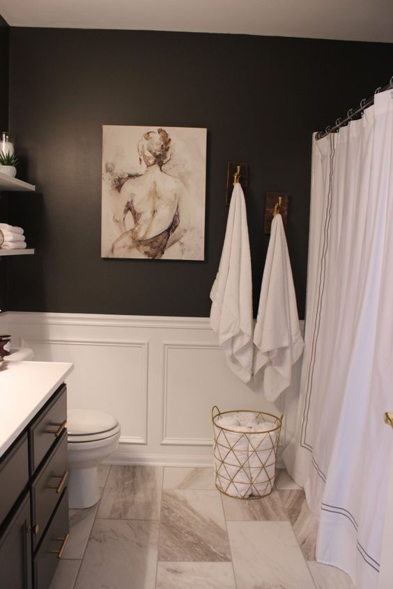 marble tiles, black walls and white wainscoting for a refined bathroom