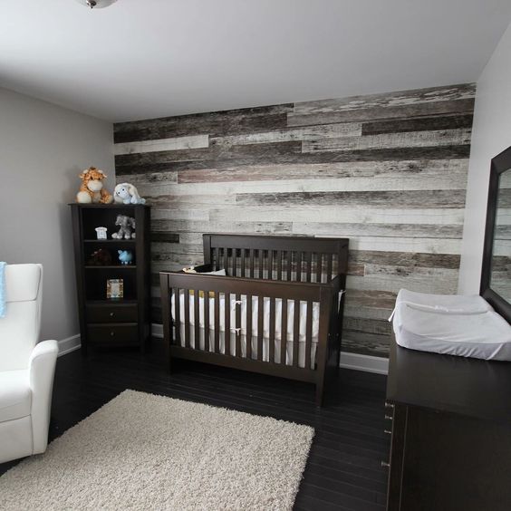 nursery with a reclaimed wood wall behind the bed for a rustic feel