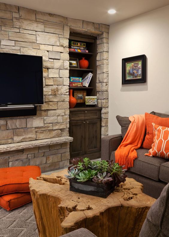 stacked stone accent wall and petrified wood coffee table bring texture and interest to the neutral space