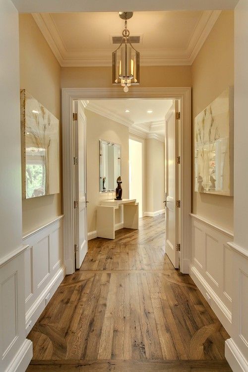 weathered wood floors with molding and cream color walls