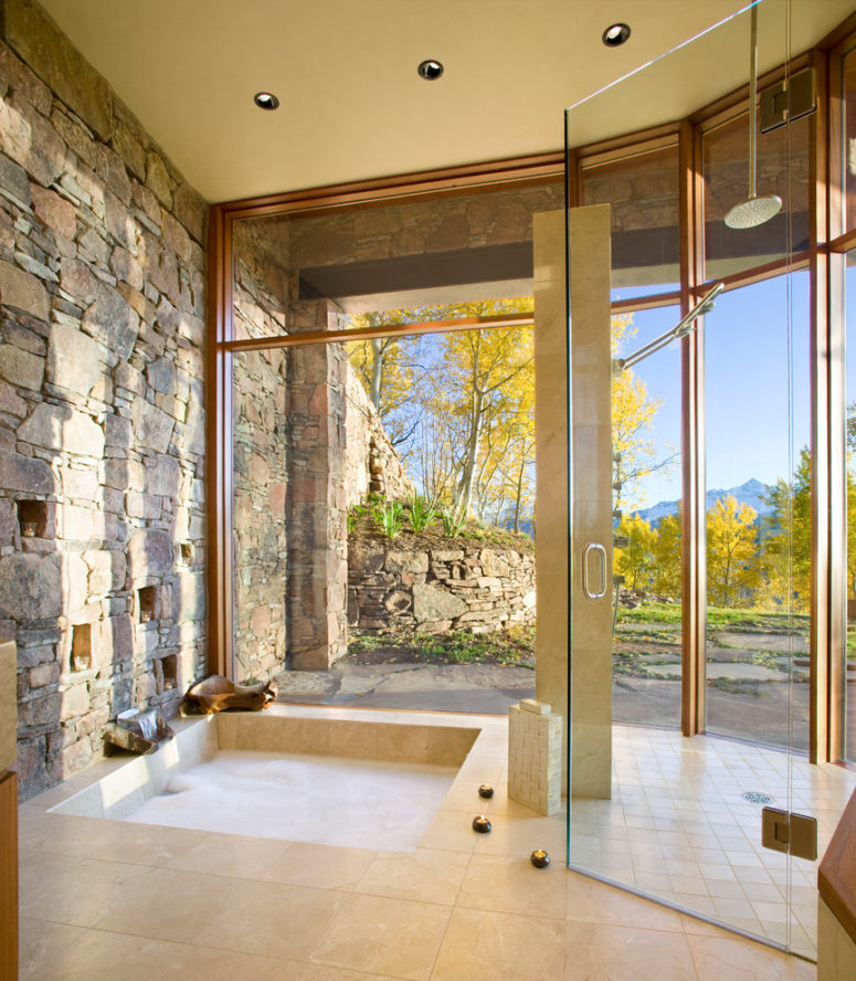 Full height glass and natural stone wall link the bathroom with the landscape around the house. (RKD Architects, Inc)