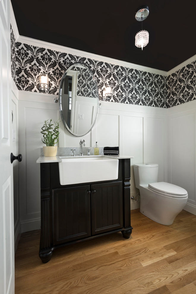 Tall white wainscoting creates strong contrast with a black ceiling in this traditional powder room.