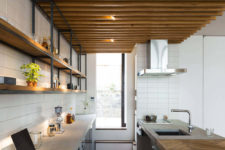 02 The kitchen is decorated with concrete and warm natural woods
