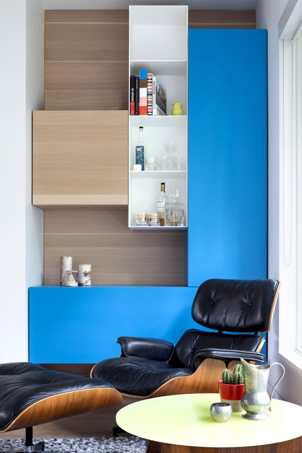 This bold relaxing nook by the window is accentuated with a blue unit and a small home bar