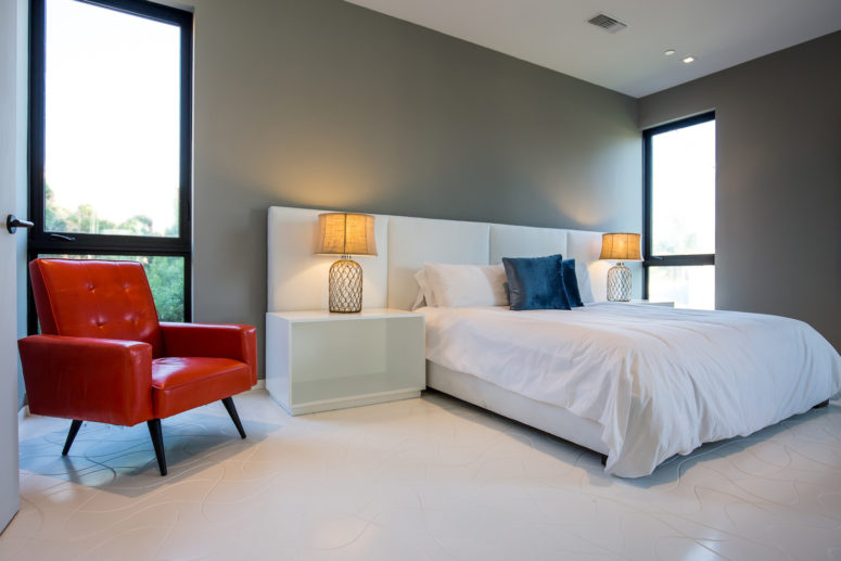 The bedroom is decorated in minimalist style with just a couple of bold accents