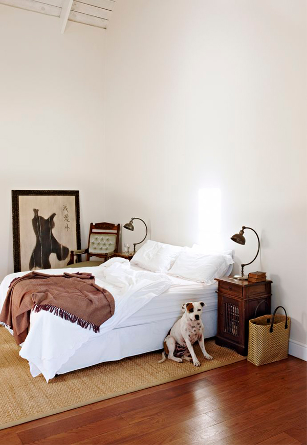 The master bedroom is very simple, with just a comfy bed, vintage nightstands and lamps and a jute rug for a textural look