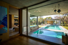 04 a pool is positioned between the two structures, bordered by wooden decking