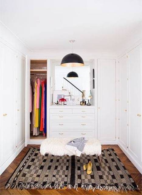 The small closet has white cabinets, a Moroccan rug and a faux fur ottoman