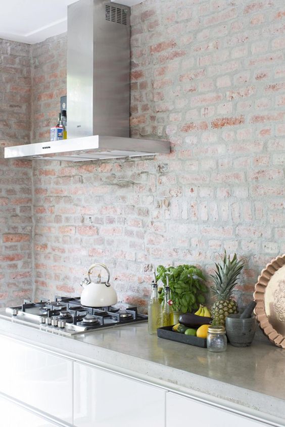 antique whitewashed brick wall contrasts with modern kitchen design