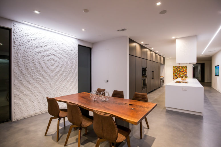 The dining space is accentuated with a large textural geometric wall art