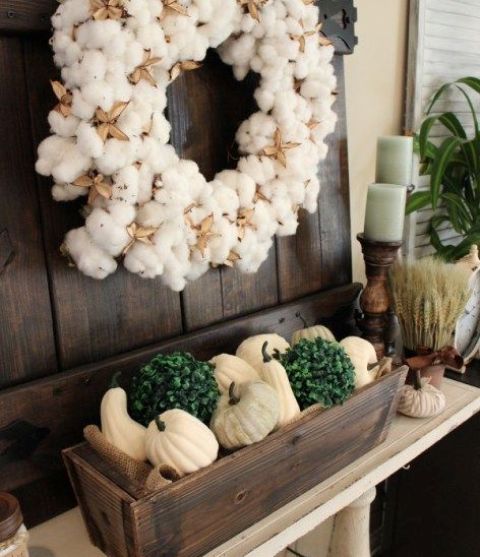 boxwood planter with white pumpkins and silk flowers, a cotton wreath