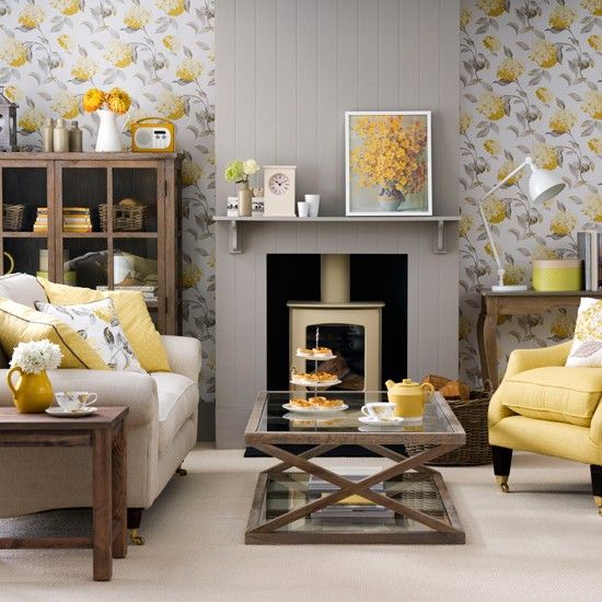 grey and yellow floral wallpaper, a grey fireplace panel and a yellow chair and pillows