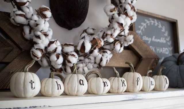simple mantel decor with white faux pumpkins and a cotton wreath