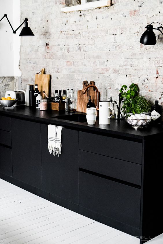sleek black cabinets and vintage whitewashed wall leave an impression