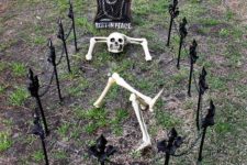 09 set up a skeleton head, arms, and legs as if he’s relaxing on his final resting spot