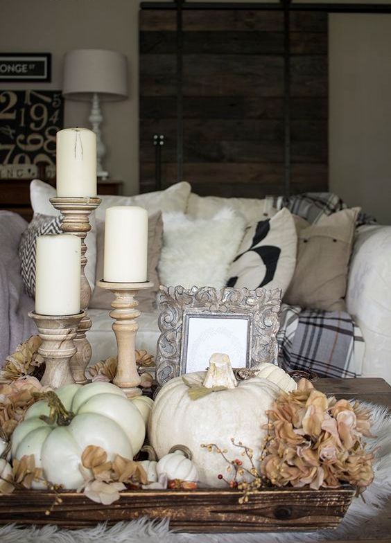 coffee table display with silk flowers, pillar candles and white pumpkins