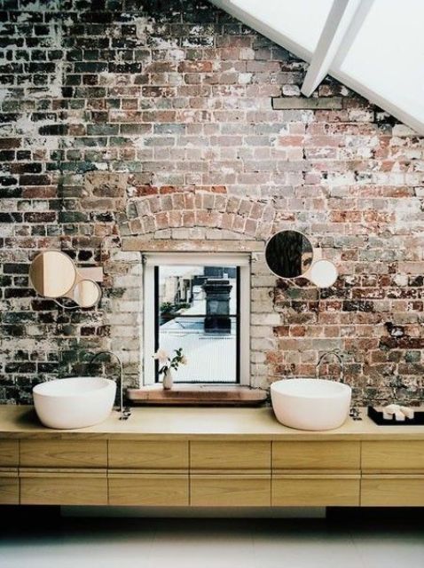 exposed brick wall with mirrors on it