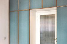 14 framed blue fabric panels accentuate the entrance to the room