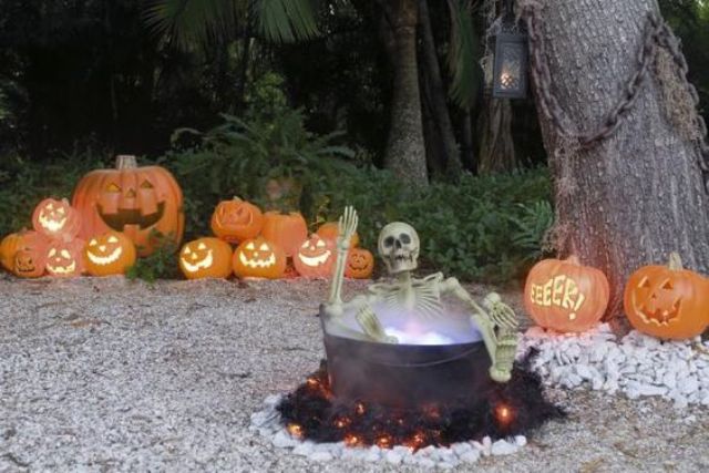 Yard haunt with a skeleton in a cauldron and jack o lanterns