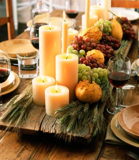 wooden board with grapes, gourds and candles