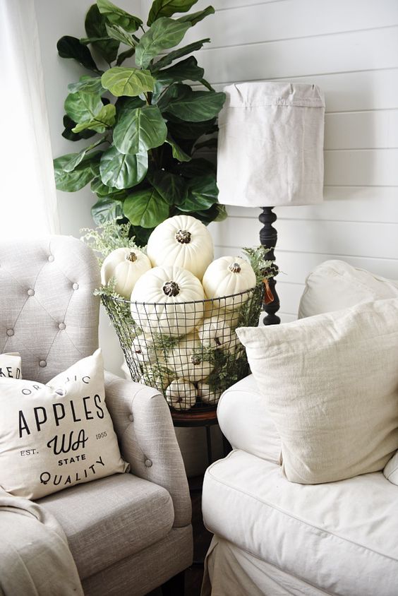 neutral fall decor with a wire basket full of pumpkins